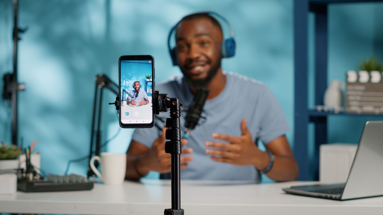 Mann nimmt Video mit Smartphone auf, unterstützt von TikTok Agentur für authentisches Influencer-Marketing