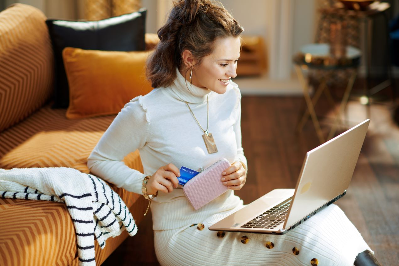 Frau beim Online-Shopping am Laptop mit Kreditkarte – unterstützt durch eine Amazon Agentur