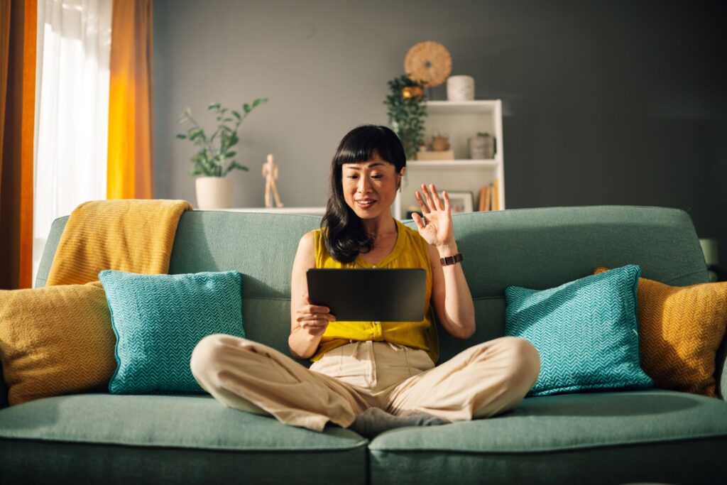 Person nimmt an einem Online-Meeting mit Tablet teil.