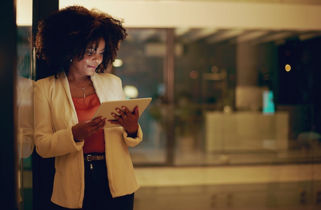 Professionelle Frau nutzt ein Tablet zur Lohnabrechnung in einem modernen Büro – flexibles Lohnbüro-Management.