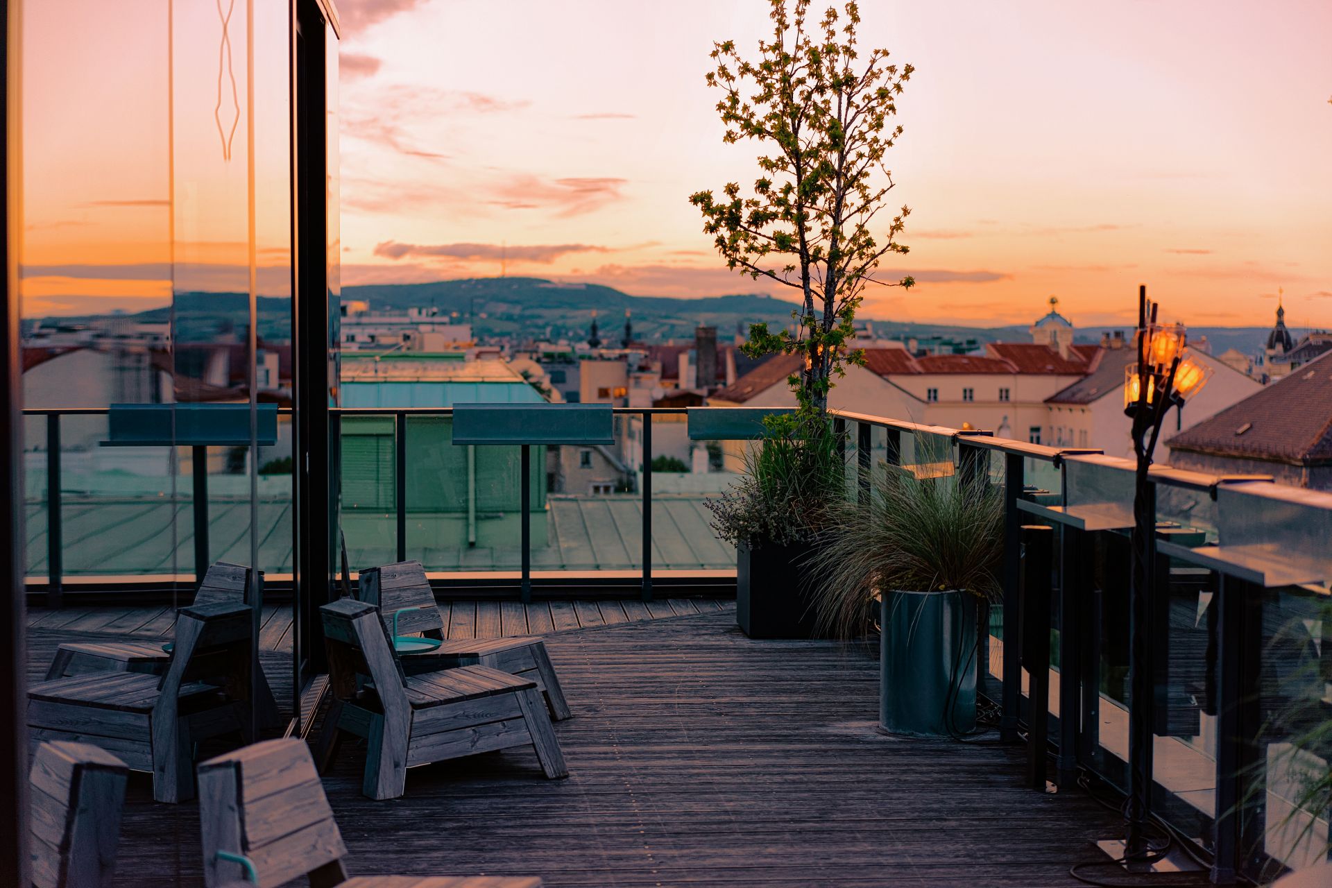 Rooftop-Terrasse mit Stadtblick ueber Wien im Sonnenuntergang