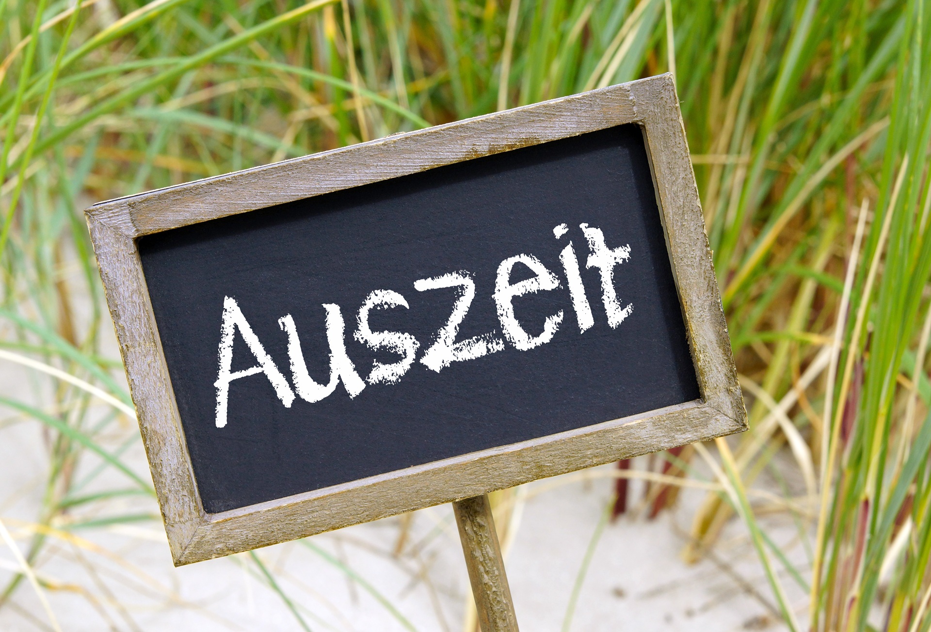 Holzschild mit Aufschrift Auszeit | Wellnesshotel in Bayern