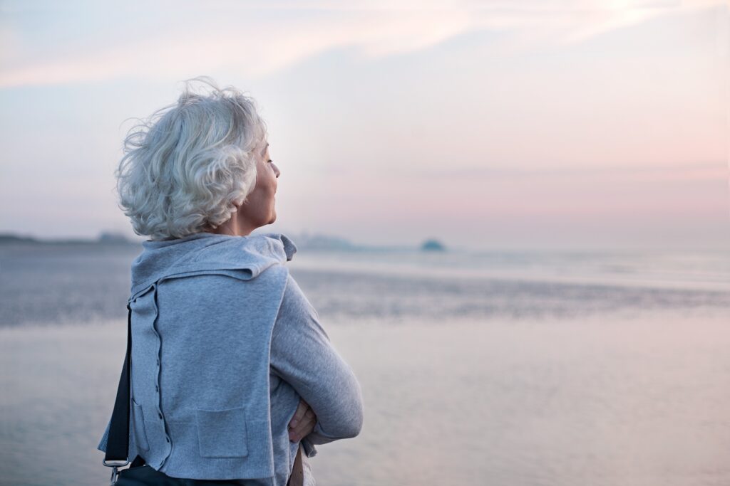 Frau genießt Meerblick bei Sonnenuntergang | Wellnesshotel in Bayern