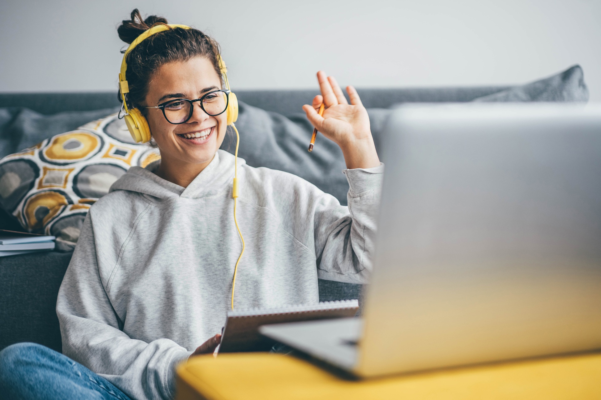 Frau lernt online mit Laptop und Kopfhörern | E-Learning Anbieter