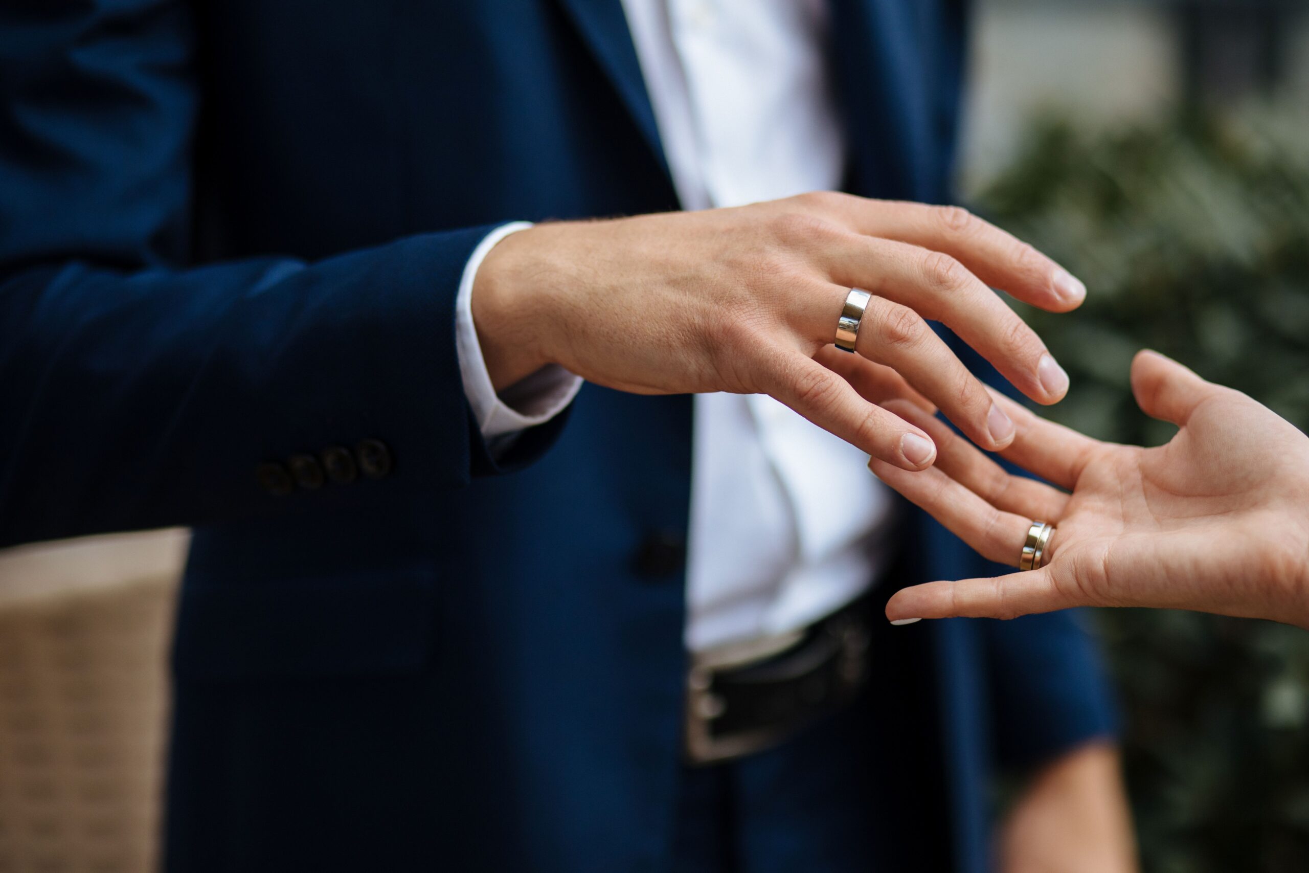 Eheringe für Männer bei der Anprobe, Nahaufnahme von Händen mit modernen Ringen